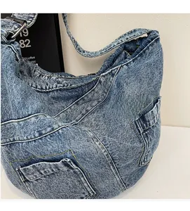 Detailed macro view of light blue denim fabric texture and external stitching on crossbody bag