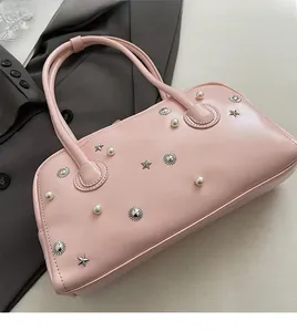Detail of pink PU leather bag with pearls, metal stars, and sunburst rivets