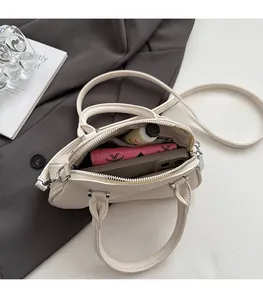 Interior view of off-white lychee leather shell bag showing large storage capacity