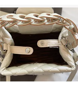 Close-up of white quilted bucket bag featuring a secure magnetic snap closure design