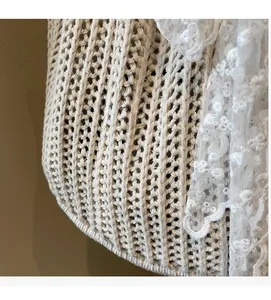 Detailed close-up of beige woven fabric with elegant white floral lace embroidery edge