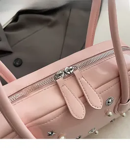 Detail of pink patent leather bag showing double zippers and pearl star decorations