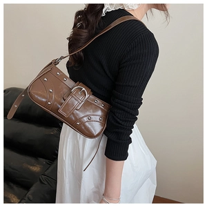 Détail du sac sous le bras marron vintage avec rivets argentés et grande boucle