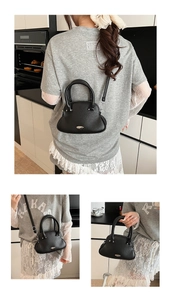 Detail of black litchi grain leather tote with silver metal hardware and crossbody strap