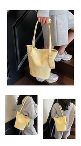 Detail of yellow crocodile embossed tote bag with metal ring buckle and shoulder strap