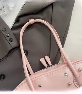 Detail view of pink shoulder bag featuring silver star ornaments and pearl charms
