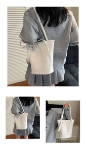 Detail of white crocodile pattern bucket bag showing textured PU leather and strap