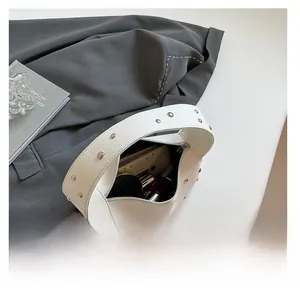 Internal view of white leather baguette bag with silver studs showing daily essentials