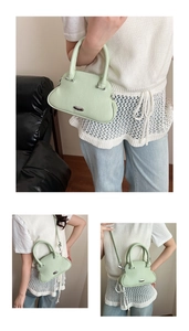 Detail of mint green shell bag featuring lychee grain texture and silver hardware