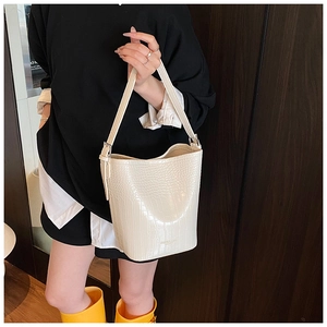 Detail of white crocodile pattern bucket bag with adjustable wide shoulder strap