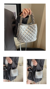 Detail of silver quilted bucket bag featuring stud accents and woven top handle