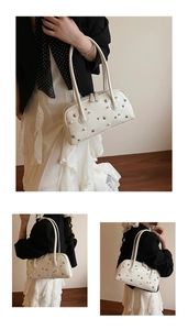 Detail of cream white shoulder bag with silver star rivets, pearls and faux leather texture