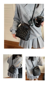Detail of black quilted bucket bag with pearl accents and woven vintage bronze handle