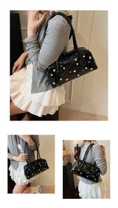 Detail of vintage black shoulder bag with pearl and star stud embellishments in use
