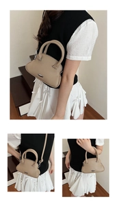 Detail of trendy beige lychee grain shell bag with metal plate and crossbody strap