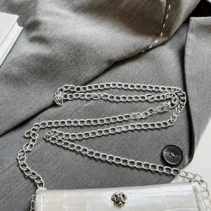 Close-up of a silver chain strap on a faux crocodile texture small square bag for women