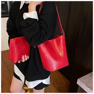 Detail of red crocodile texture bucket bag and matching pouch with premium PU leather finish