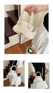 Macro view of white lychee-patterned leather shell bag with elegant metal hardware
