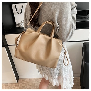 Detail of beige pleated crossbody bag showing soft PU texture and elegant top handles