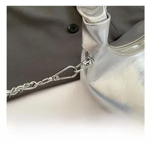 Gros plan du sac plissé argenté avec crochets métalliques de qualité et chaînes tressées
