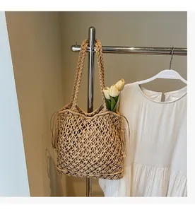 Détail du sac cabas beige tissé main avec cordon à franges et texture en maille