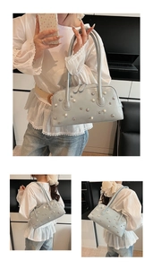 Detail of grey-blue shoulder bag featuring elegant pearl and star-shaped metal studs