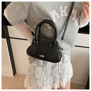 Model view of black pebble leather mini handbag with silver hardware and shoulder strap