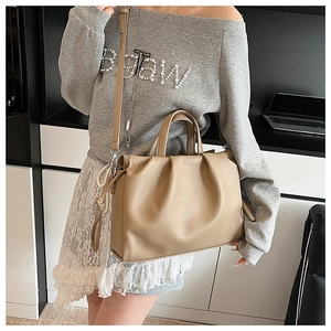Detail der khakifarbenen Plissee-Tasche mit weicher Textur und verstellbarem Riemen