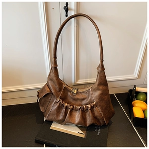 Detail of vintage brown pleated hobo bag showing retro leather texture and side pocket