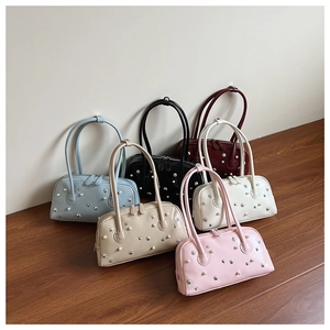 Flat lay showing six colors of pearl and star rivet decorated shoulder bags on wooden floor