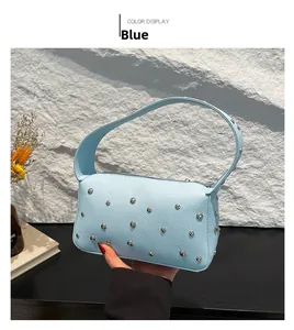 Detail view of light blue lychee grain leather underarm bag with silver stud rivets