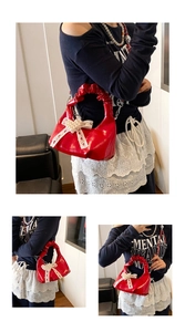 Détail du sac rouge verni avec cœur en perles et nœud en dentelle élégant