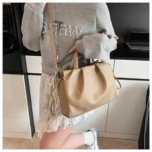 Detail view of the elegant beige pleated dumpling bag featuring pebble grain leather texture