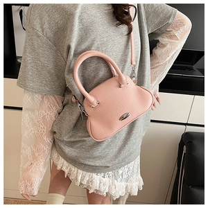 Detailed close-up of pink shell-shaped cloud bag with pebble leather and metal ring handle