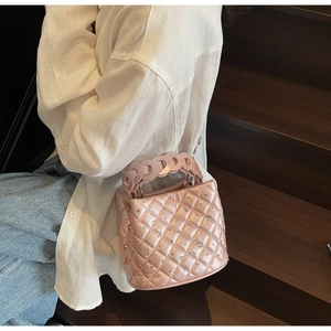 Quilted pink bucket bag with rhinestones and woven handle on a casual lifestyle setting