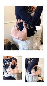 Détail du sac coquillage rose brillant avec anse froncée et breloque perle et nœud