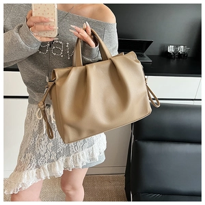 Detailansicht der khakifarbenen Leder-Beuteltasche mit Plissee-Design und Griffen