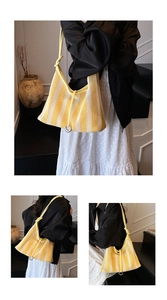 Détail du sac cabas en maille rayée jaune et blanc avec anneau en métal et bandoulière