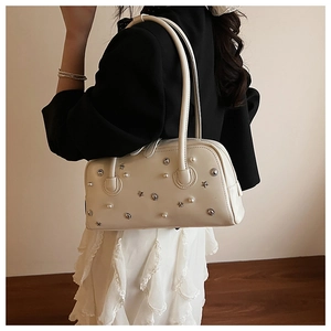 Detail of cream rectangle shoulder bag with star rivets and pearls on faux leather