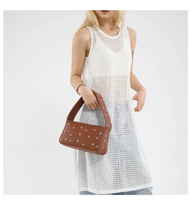 Borsa a spalla in pelle marrone con rivetti in argento mostrata da una modella