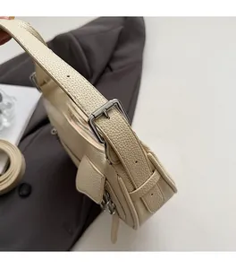 Detail of adjustable strap with silver hardware on beige pebbled leather shoulder bag