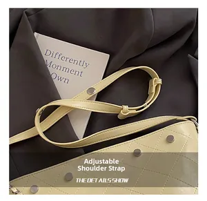 Detail showing adjustable strap and silver rivets on beige quilted bucket bag