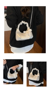 Détail du sac coquille avec poignée froncée, nœud en perles et chaîne argentée