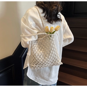 Détails d'un sac cabas en macramé blanc fait main avec glands et accents floraux de tulipes