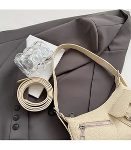 Detail of a creamy white lychee pattern hobo bag with a zipper pocket on a suit background