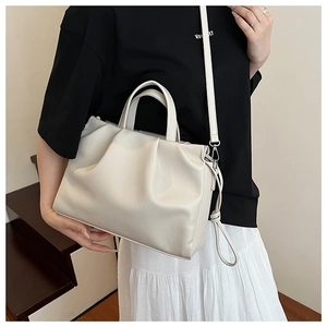 Detail der cremefarbenen Ledertasche mit Litschi-Struktur und Plissee-Design