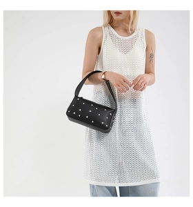 Close-up of black leather shoulder bag with silver studs and smooth punk style texture