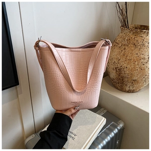 Detail of pink crocodile pattern bucket bag showing textured leather and fashion logo
