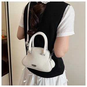 Close-up of white lychee texture leather handbag on model showing crossbody styling