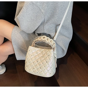Close-up of diamond-studded rhombic quilted leather texture on pearl white bag
